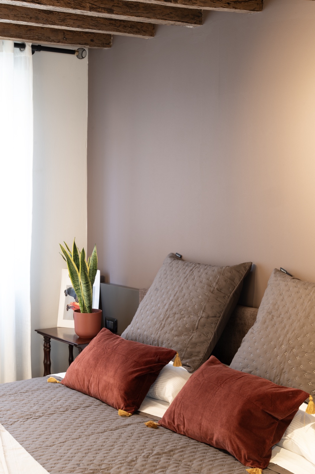 The bed in the Grasparossa Suite with terracotta-coloured cushions