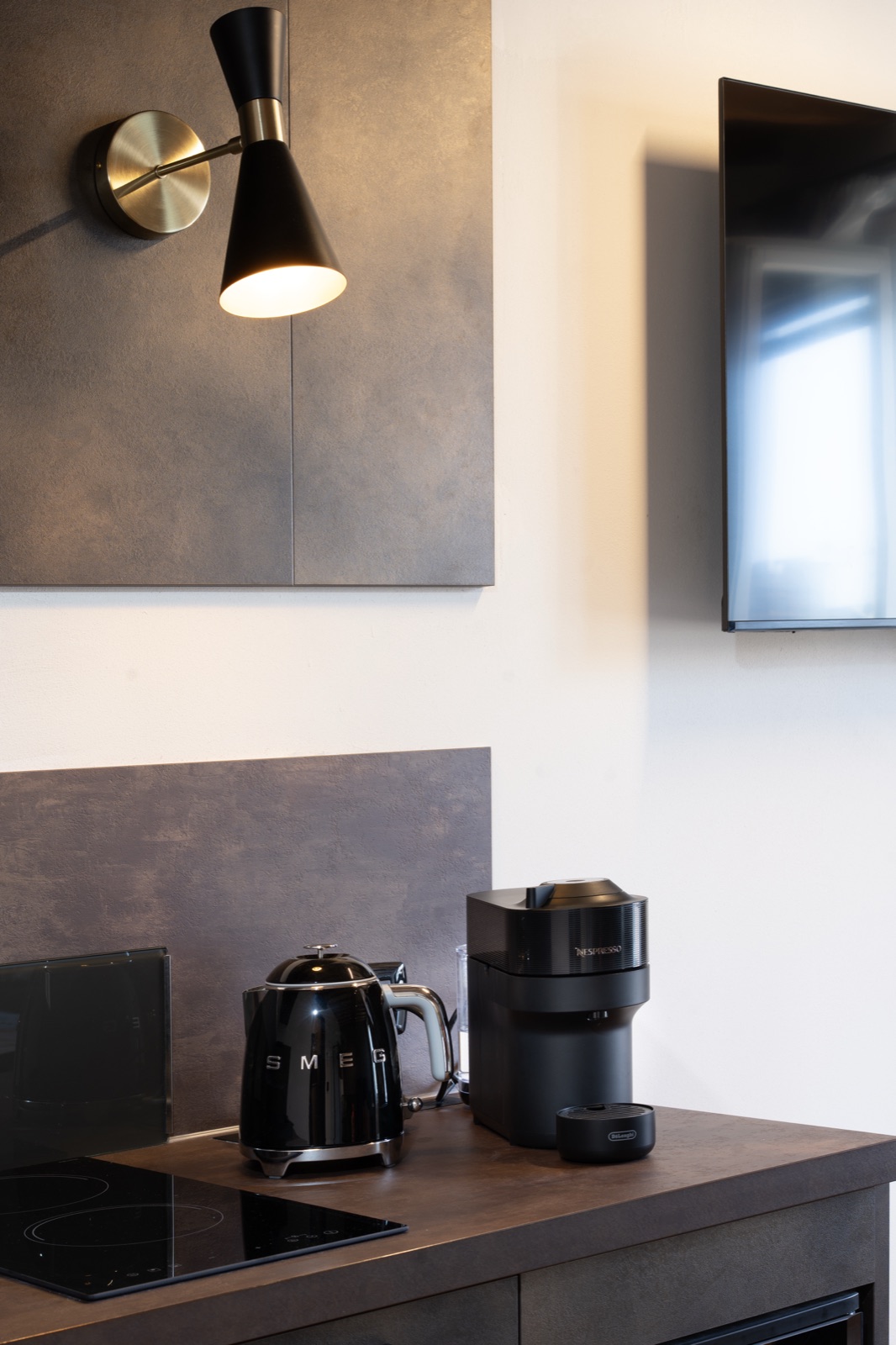 L'angolo cucina con il bollitore, la macchina del caffè e la lampada a parete