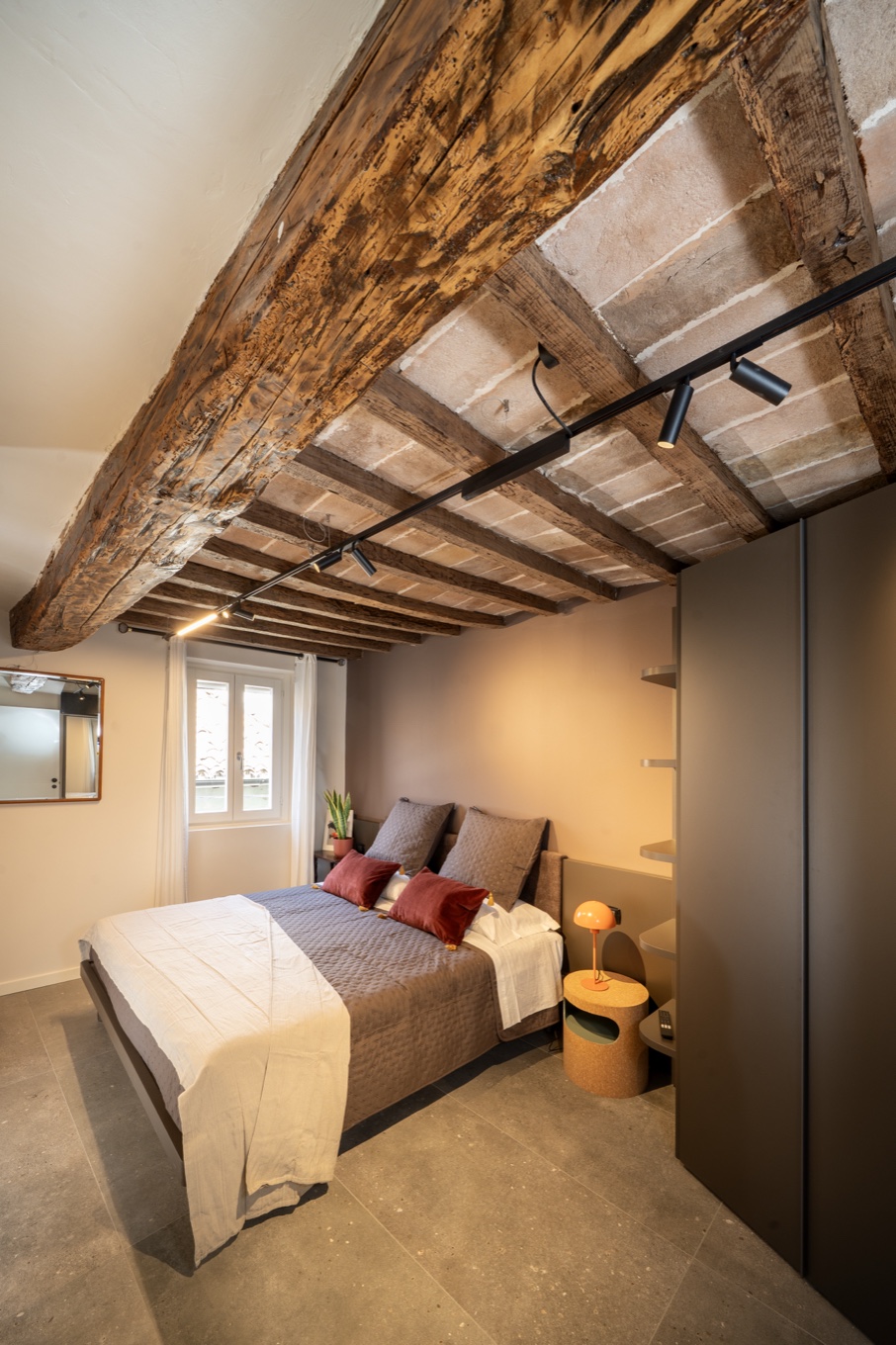The Grasparossa Suite with the large restored beam and the bed beneath the exposed ceiling
