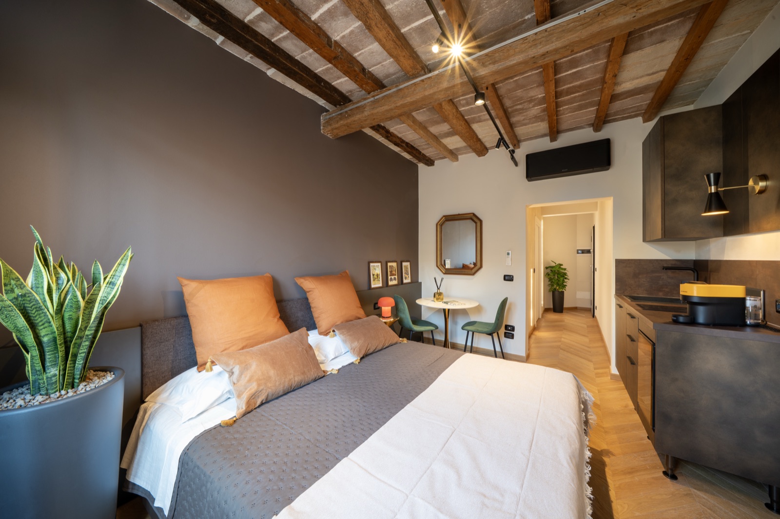 La suite per intero: letto, angolo cucina e soffitto travato