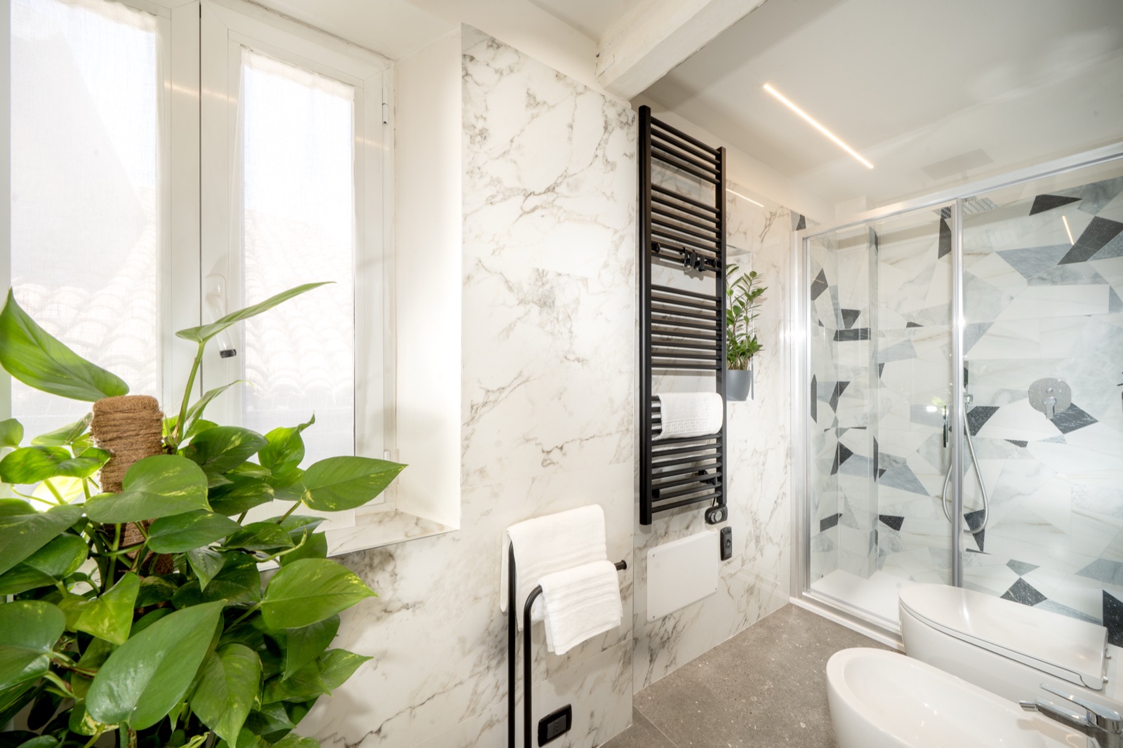 The marble bathroom with the heated towel rail and the shower at the far end