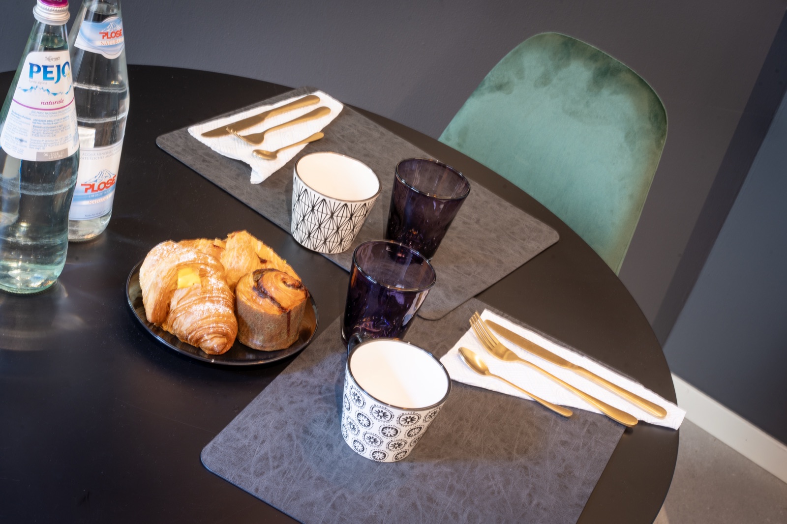 The table laid for breakfast, with croissants and cups