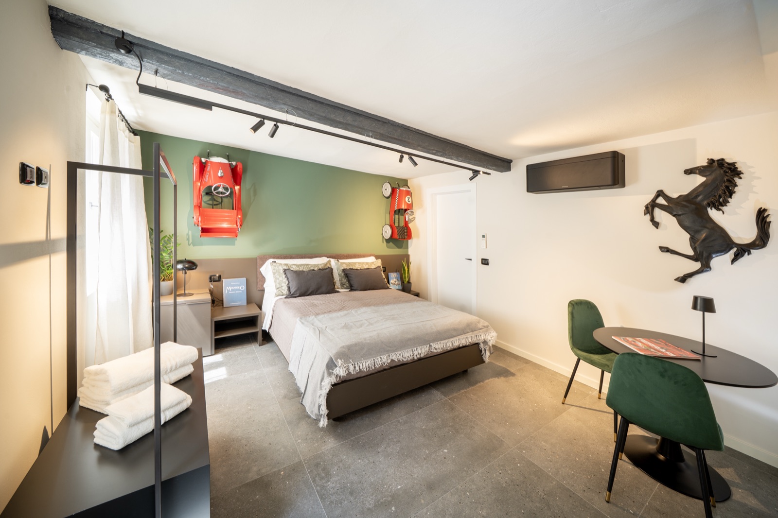 The whole Hombre Suite: the bed, the green wall with the tin car and the desk